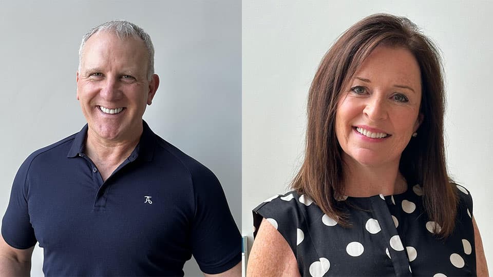 A headshot of Martin and his wife Sharon. He is wearing a navy t-shirt and Sharon is wearing a polka dot top in navy. They are both smiling at the camera.